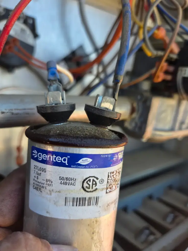 Failed AC capacitor removed during a repair