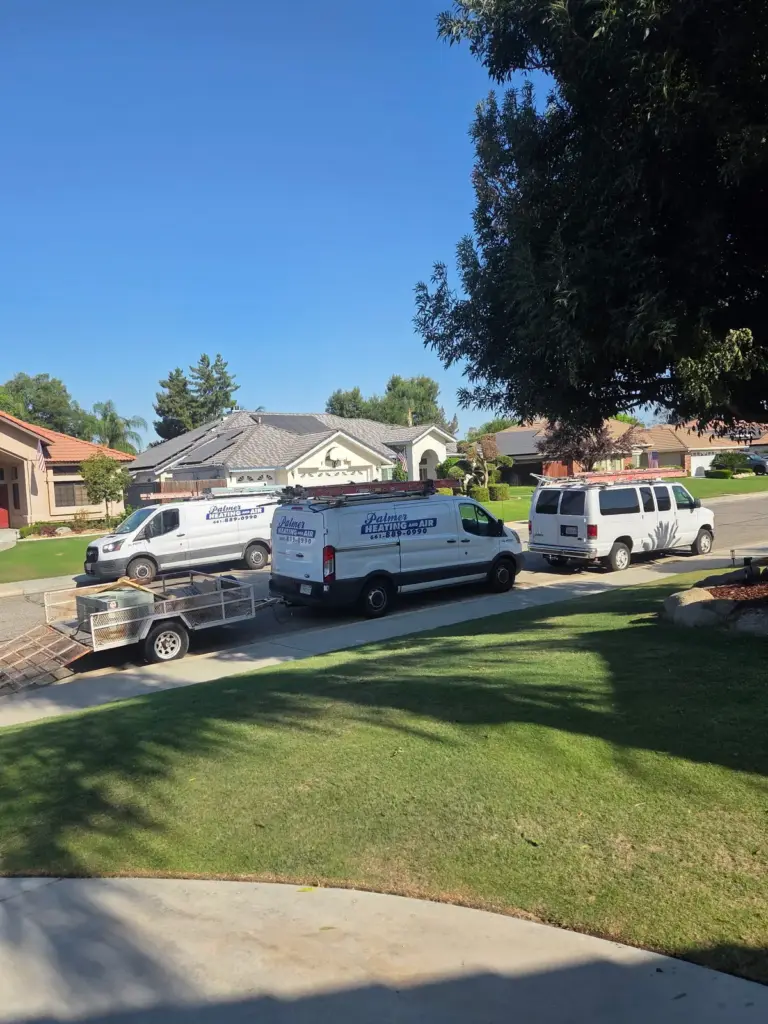 Palmer Heating and Air service vans and equipment trailer parked at a job in Bakersfield