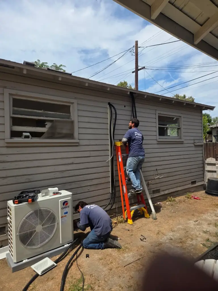 Palmer technician installing a mini-split outside a home