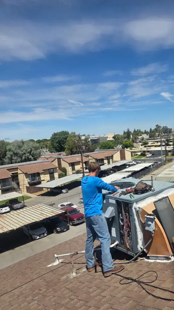 Palmer technician working on a rooftop heating and cooling package unit in Bakersfield